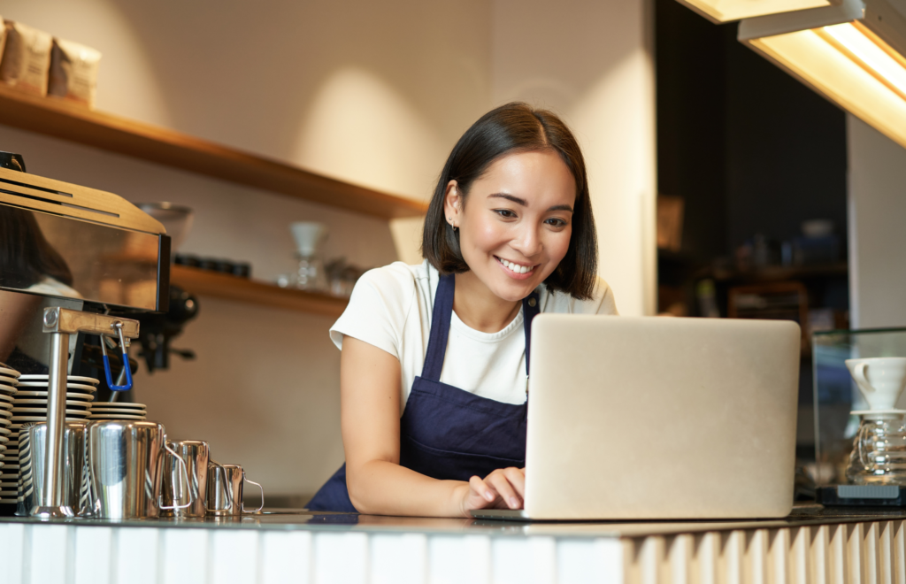 Lady In A Restaurant Reading How To Build A Restaurant Business Plan