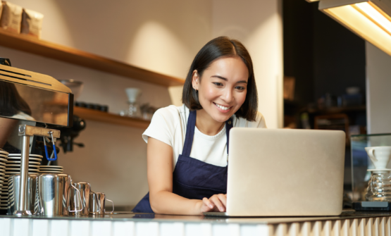 Lady In A Restaurant Reading How To Build A Restaurant Business Plan