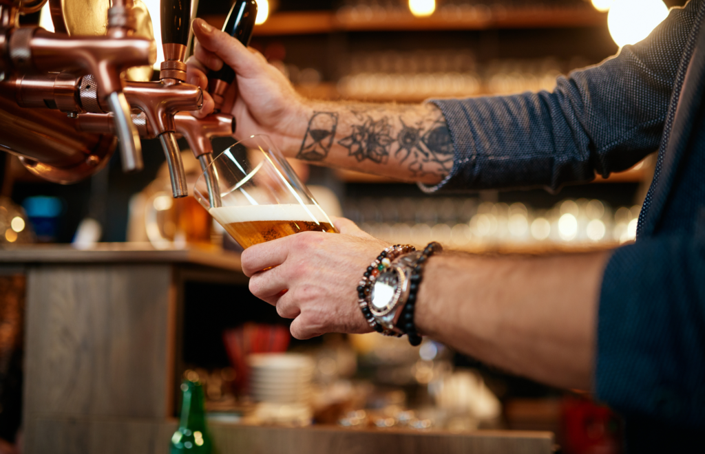 Man pouring pint after learning how to make a bar profitable