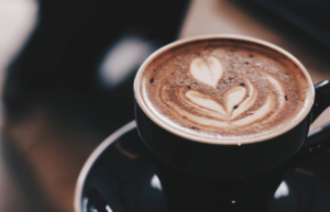 A barista-made coffee with a design placed on top.