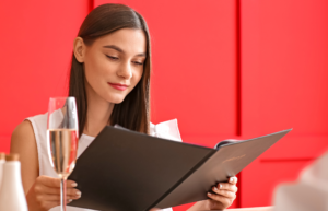 Woman reading at a restaurant that has followed a pricing strategy for restaurant menu 