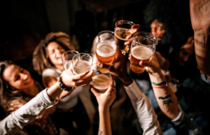 Happy customers saying cheers with their pints, as a result of an effective pub business plan