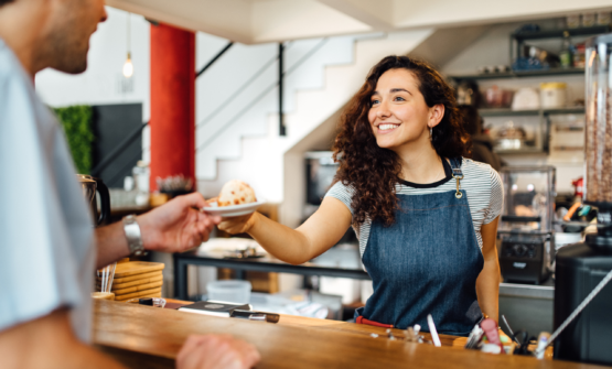 Barista serving a customer at cafe